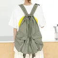 Sage green nylon drawstring backpack featuring pleated design and front zipper pockets - Green