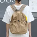 Casual khaki nylon drawstring backpack with pleated texture worn by a female model outdoors - Khaki