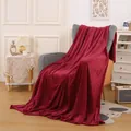 Couverture en flanelle rouge bordeaux quadrillée drapée sur un fauteuil de salon chaleureux - Plaid / Boîte cadeau / Bordeaux