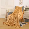 Gelbe Flanelldecke mit Rautenmuster auf einem Sessel in einem gemütlichen Wohnzimmer - Hellkaffee