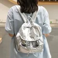 Modern shiny metallic silver backpack featuring buckle closure and drawstring detail - Silver