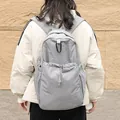 Casual grey nylon backpack featuring unique pleated fabric and drawstring pocket details - Light Gray