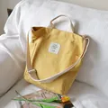 Minimalist yellow canvas tote bag with adjustable shoulder strap and top handles - Yellow
