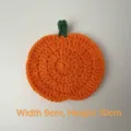 Primo piano di sottobicchiere a zucca all'uncinetto con misure 9x10 cm - Sottobicchiere Zucca / 9cmx10cm / Arancione