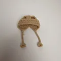 Detailed view of handmade khaki knitted mini hat for dolls featuring straps and ties - Khaki