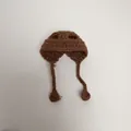 Detailed view of a handmade brown crochet mini hat with ear flaps for doll accessories - Coffee
