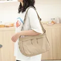 Lässige japanische Umhängetasche aus Nylon in Khaki, getragen von einem Modell im Alltag. - Khaki