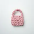 Primer plano de un mini bolso rosa tejido a mano con hilo de chenilla suave y esponjoso - Rosa Loto