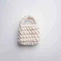 Detalle de un mini bolso artesanal hecho a mano con hilo de lana grueso color blanco crema - Beige