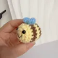 Detail van een handgemaakte gehaakte bijenhanger met gele en bruine strepen. - Bij met Blauwe Vleugels