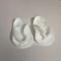 Nahaufnahme der weichen handgehäkelten Textur der weißen Baby-Flip-Flop-Hausschuhe. - Weiß