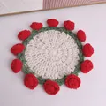Close-up of a handmade crocheted rose flower coaster with 3D red petals and green border - Rose Coaster / Red