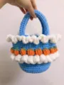 Close-up van handgemaakte gehaakte mand met witte ruches en oranje aardbeien - Blauw