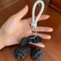 Vista dettagliata di un portachiavi a ciliegia intrecciato nero a mano con laccio bianco - Ciondolo per Auto / Taglia S / Nero