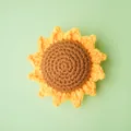 Accesorio de girasol amarillo tejido a mano sobre un suave fondo verde menta pastel - Cabeza de Girasol / Amarillo
