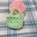 Detailansicht eines handgefertigten mintgrünen Häkel-Mini-Taschenanhängers aus Wolle - Hellgrün