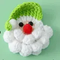 Cute handmade knitted Santa Claus brooch featuring a green hat and puffy white beard - Green Santa Style