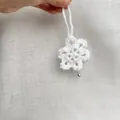 Elegant white handmade crocheted snowflake ornament featuring a tiny silver bell detail - Snowflake