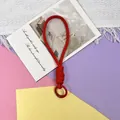 Gedetailleerde weergave van een dikke rode gevlochten telefoonpolsband op gekleurd papier - Telefoonsnoer / 1 Stuk / Rood