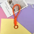 Detail view of a bright orange braided paracord lanyard featuring a sturdy metal ring attachment - Phone Cord / 1 Piece / Orange