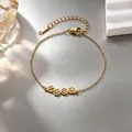 Detailaufnahme eines vergoldeten Edelstahlarmbands mit zarten ausgeschnittenen Katzenpfoten - Katzenpfoten Armband / Gold
