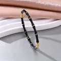 Detailansicht eines schwarz-goldenen elastischen Armbands aus Edelstahl im Bambus-Stil für Damen - Bambus Armband / Schwarz