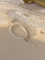 Gros plan d'un bracelet en perles avec breloque dorée de chance et pierre verte - Style Étiquette de Bénédiction en Perles