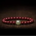 Traditional cinnabar bead bracelet with central nephrite jade bead and gold accents - Hetian Jade Style / 6mm