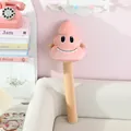 Close-up of a funny pink poop emoji plush massage stick hammer for relaxing back tapping - Height 60cm / Pink