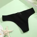 Detailed view of black ribbed cotton thong with bow on light green background - M / Black