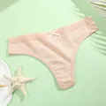 Detailed macro view showing the ribbed cotton texture and delicate bow on a peach thong - M / Pink