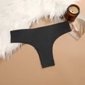 Detail view of black seamless thong underwear laid on a soft white faux fur rug - S / Bottoms / Black