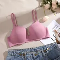 Vista de detalle de un sujetador push-up rosa sin costuras con aros sobre fondo plano - 34B / Tops / Rosa