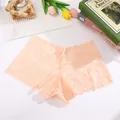 Close-up of delicate peach floral lace panties showing intricate mesh texture - Nude