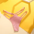 Macro-weergave van roze geribbelde stof en metalen ringdetail op dubbele string - Roze
