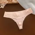 Detailopname van een lichtroze ijssijden string met een elegante kanten tailleband - Lichtroze
