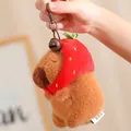 Detailweergave van een pluche capibara sleutelhanger met een rode aardbeienmuts. - 12cm / Aardbei Stijl Hanger