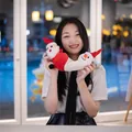 Weiches, wendbares Weihnachtsmann und Schneemann Plüschtier von einem asiatischen Model gehalten - Wendbarer Flip-Stil / 20cm / bunt