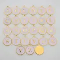 Detailed close-up view of light purple round alphabet charms with gold lettering. - Letter-M / Pink