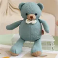 Vue détaillée d'un ours en peluche tricoté vert sauge avec un nœud papillon blanc - 30cm / Ours en peluche
