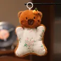 Lindo colgante de peluche de oso marrón con cuerpo de tela floral y aro. - Pequeño Carpincho
