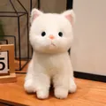 Close-up of a realistic white plush kitten toy with blue eyes on a wooden desk. - Sitting Style - White Cat / 15cm