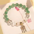 Elegantes Perlenarmband mit grünen und weißen Kristallen und goldenem Quastencharm - Grüner Erdbeerquarz Quasten-Armband