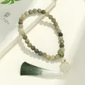Natural Bodhi seed bracelet with intricately carved beads and a green gradient tassel. - Silver Lotus Language Handheld