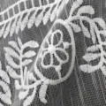 Gros plan sur tissu dentelle brodé en soie de lait blanc avec motif floral et base résille - Blanc