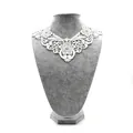 Close-up of white water-soluble lace collar with detailed floral embroidery pattern - White