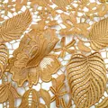 Close-up detail of golden water-soluble lace with 3D leaf and flower embroidery. - Gold