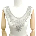 Detail einer eleganten weißen Guipure-Spitzen-Ausschnitt-Applikation - Grau