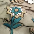 Detailed macro shot showing heavy colorful floral embroidery on organza mesh fabric texture - Black White Green Brown