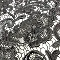 Makroansicht von schwarzem wasserlöslichem Spitzenstoff mit detaillierter Paisley-Stickerei - Schwarz